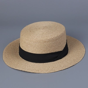Détail d'un chapeau de paille en raphia avec ruban noir et tissage artisanal
