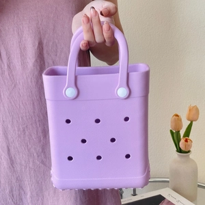 Detail of purple EVA tote bag with hole design held by a model for size reference