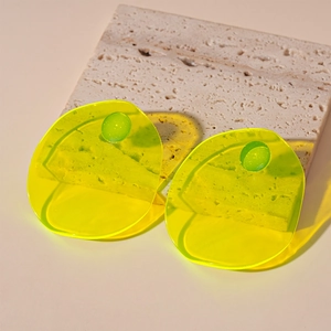 Detail view of neon yellow translucent geometric resin earring on stone base