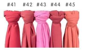 Close-up of lightweight pearl chiffon hijabs in various shades of red and pink
