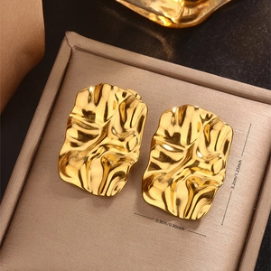 Close-up of gold irregular wrinkled texture rectangular earrings on velvet box