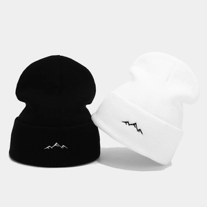 Knit beanies in black and white with mountain embroidery for a minimalist outdoor style