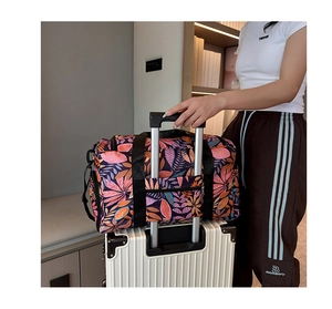 Travel tote bag with leaf print showing the trolley sleeve attached to luggage handle