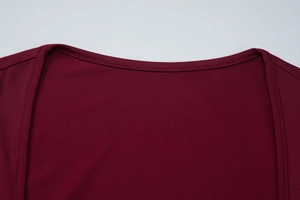 Détail de l'encolure rouge vin montrant les coutures de qualité et la texture en maille fine