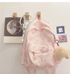 Pink canvas backpack with cartoon bear prints and yellow star plush keychain detail