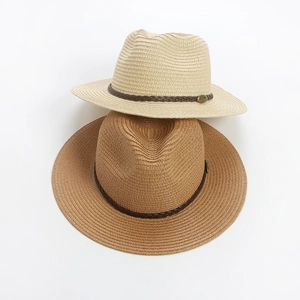 Close-up of woven paper straw hats with leather bands and vintage metal buckles
