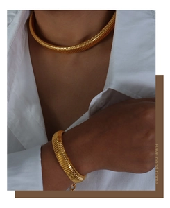 Detail of gold snake chain necklace and bracelet set with metallic luster on model