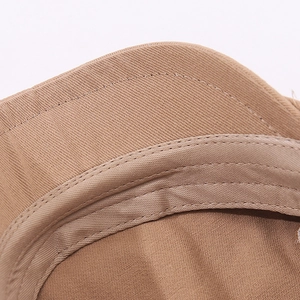Dettaglio macro del cappuccio in cotone kaki con cuciture doppie e fascia antisudore