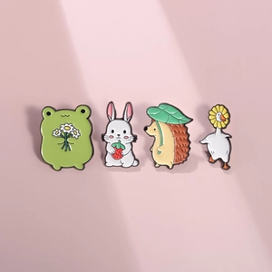 Detailed view of four cute animal enamel pins including frog, bunny, hedgehog and goose
