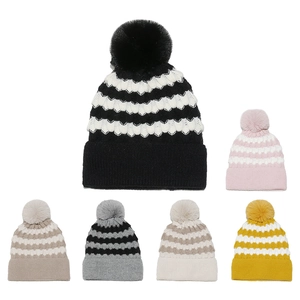 Detailed grid of knitted beanies with fluffy pom-poms in various striped color combinations