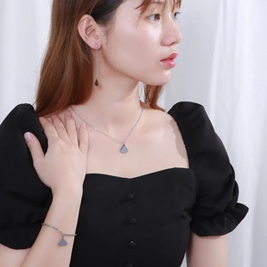 Elegant silver stainless steel jewelry set featuring fan-shaped pendants on a female model