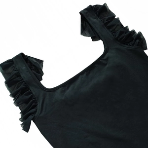 Close-up of square neckline and ruffled mesh trim on a black dress strap