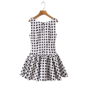 Detailed view of black and white checkered sleeveless dress with decorative front buttons
