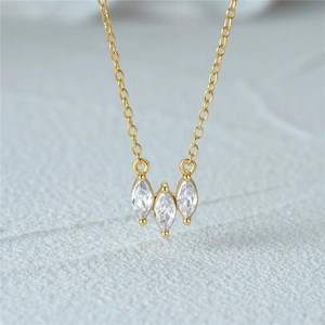 Macro detail of 18k gold necklace with three marquise-cut marquise stones in a cluster