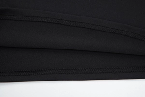 Vue macro détaillée du tissu noir tricoté avec coutures à double aiguille sur l'ourlet