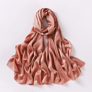 Close-up of salmon pink chiffon scarf with silky satin texture and soft draped folds