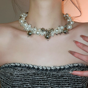 Macro detail of French style beaded necklace with alternating white pearls and silver metal balls
