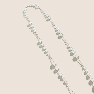 Close-up of elegant gradient pearl eyewear chain with fine gold metal link details