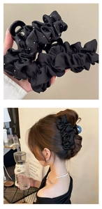Détail d'une pince à cheveux en satin plissé noir avec des décorations scintillantes