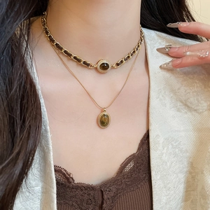 Dettaglio di una collana a doppio strato placcata oro 18k con occhio di tigre su modella