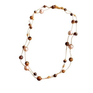 Vintage tiger eye bead necklace with pearls and gold accents on white background