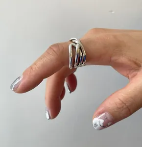 Close-up of minimalist layered silver ring showing intersecting polished line details