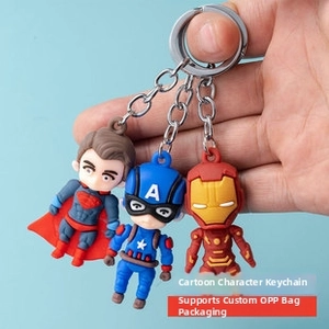 Close-up of Marvel and DC character keychains including Superman and Iron Man in hand
