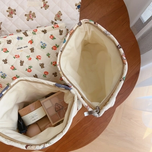 Quilted cotton makeup bag set with cute bear print and floral patterns on a wooden desk