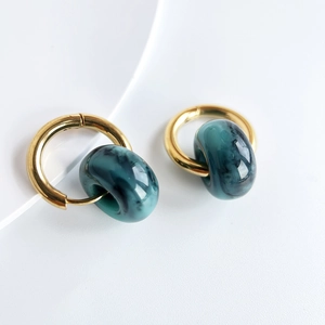 Detailed view of 18k gold plated stainless steel hoops with green marble resin beads
