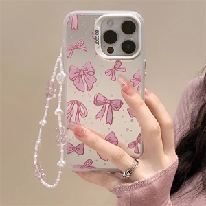 White iPhone case with pink bow pattern and pearl wrist strap held by hand