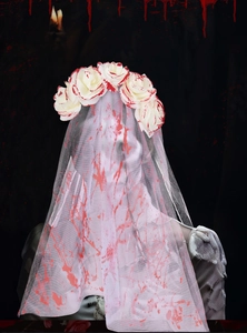 Close-up of Halloween ghost bride headband with red blood splatter on white roses and veil