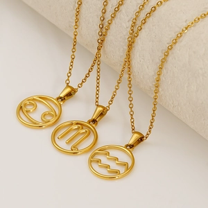 Three gold stainless steel zodiac necklaces with circular hollow pendants on texture props