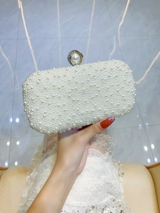 Dettaglio dell'elegante pochette da sera con perle bianche e chiusura di lusso