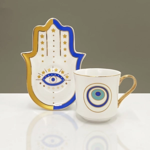 Dettaglio del piattino in ceramica a forma di mano di Hamsa con motivo Evil Eye e oro