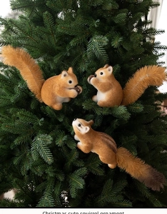 Detailed close-up of three brown plush squirrel ornaments hanging on a Christmas tree