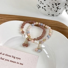 Close-up of colorful gemstone bead bracelets with shell charms and gold pendants