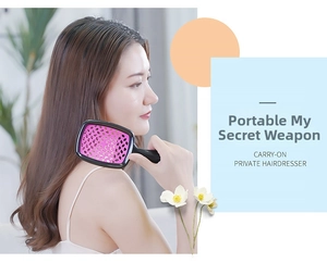 Nahaufnahme der hohlen Haarbürste mit rosa Wabendesign bei der Anwendung