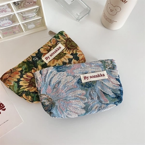 Detailed view of French embossed floral pouch set with jacquard texture and metal zipper