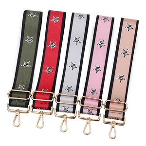 Adjustable bag straps set with leopard star patterns and gold hardware on white background