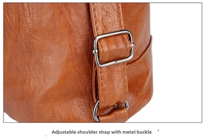 Detail of adjustable shoulder strap with silver metal buckle on brown faux leather bag