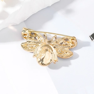 Macro detail of the golden bee brooch back featuring a secure safety pin fastener