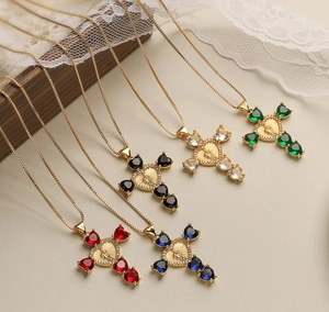 Close-up of gold 18K plated cross necklaces with heart-shaped gems and Virgin Mary medal