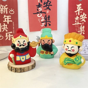 Hand-carved wooden Chinese God of Fortune figurine set on a festive white desktop