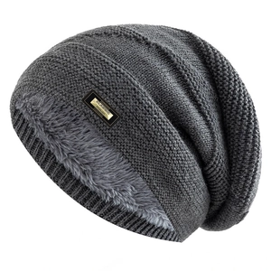 Detail of dark grey knit beanie with thick faux lamb wool lining and metal logo tag