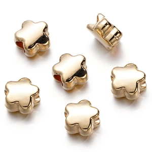 Macro shot of gold floral metal beads for DIY jewelry making on white background