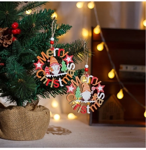 Close-up of Merry Christmas wooden tree ornaments hanging with warm festive bokeh lights