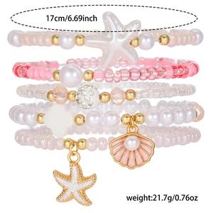 Close-up of five-piece beaded bracelets with pink pearls and starfish shell pendants