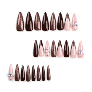 Brown and pink stiletto press-on nails with glitter and rhinestone accents on white background