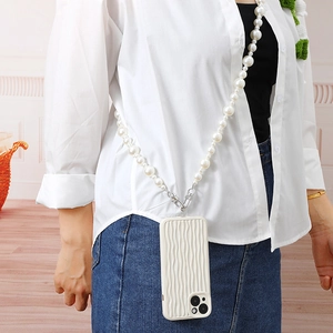 White pearl crossbody phone lanyard with handmade beads on a textured white case