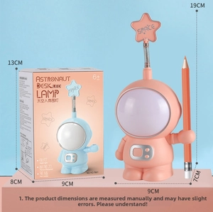 Pink astronaut LED lamp showing integrated pencil sharpener and storage details